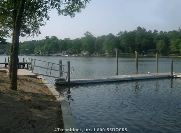 TechniDock aluminum composite floating dock with gangway on calm tree-lined river