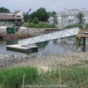 Short aluminum gangway leading from floating desk to wooden dock